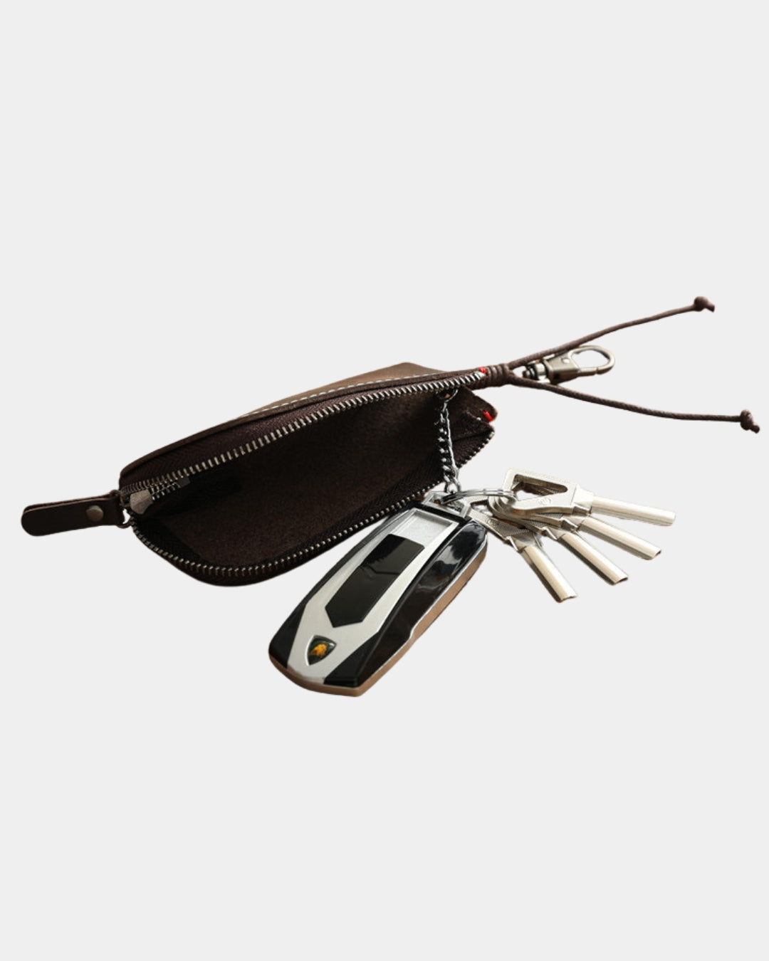 Compact brown genuine cowhide leather key wallet with a zippered compartment, metal key ring, and clip holding car keys.