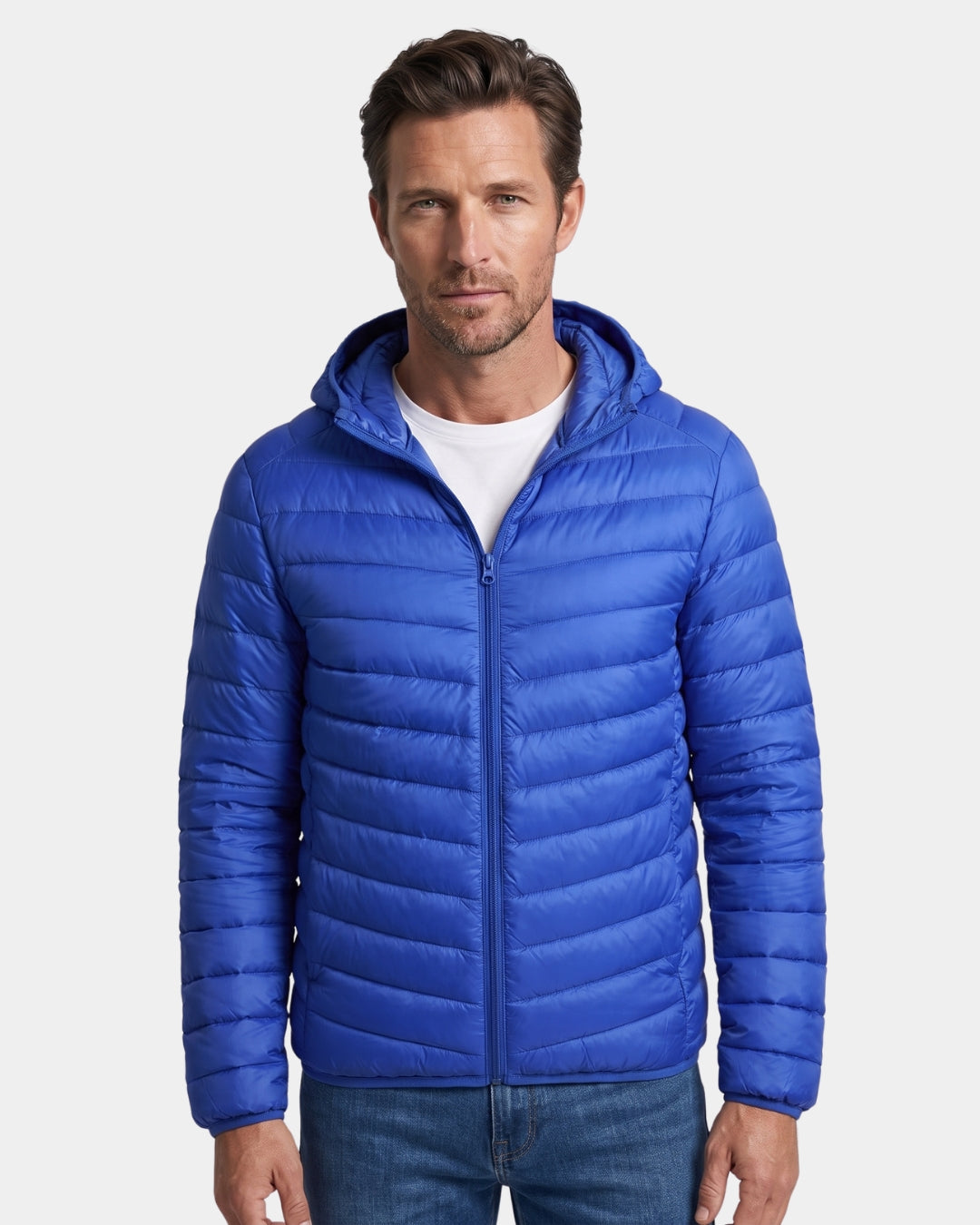 Man wearing a royal blue, lightweight hooded puffer jacket with a quilted design and full-zip front.