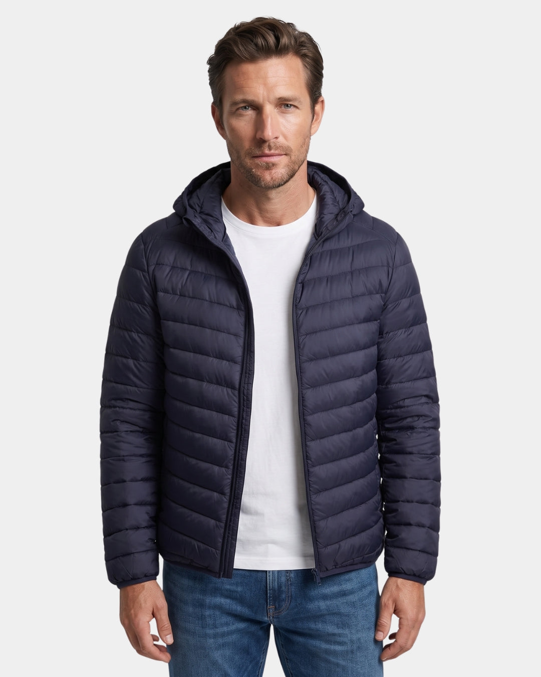Man wearing a navy blue lightweight hooded puffer jacket with a quilted design and full-zip front.