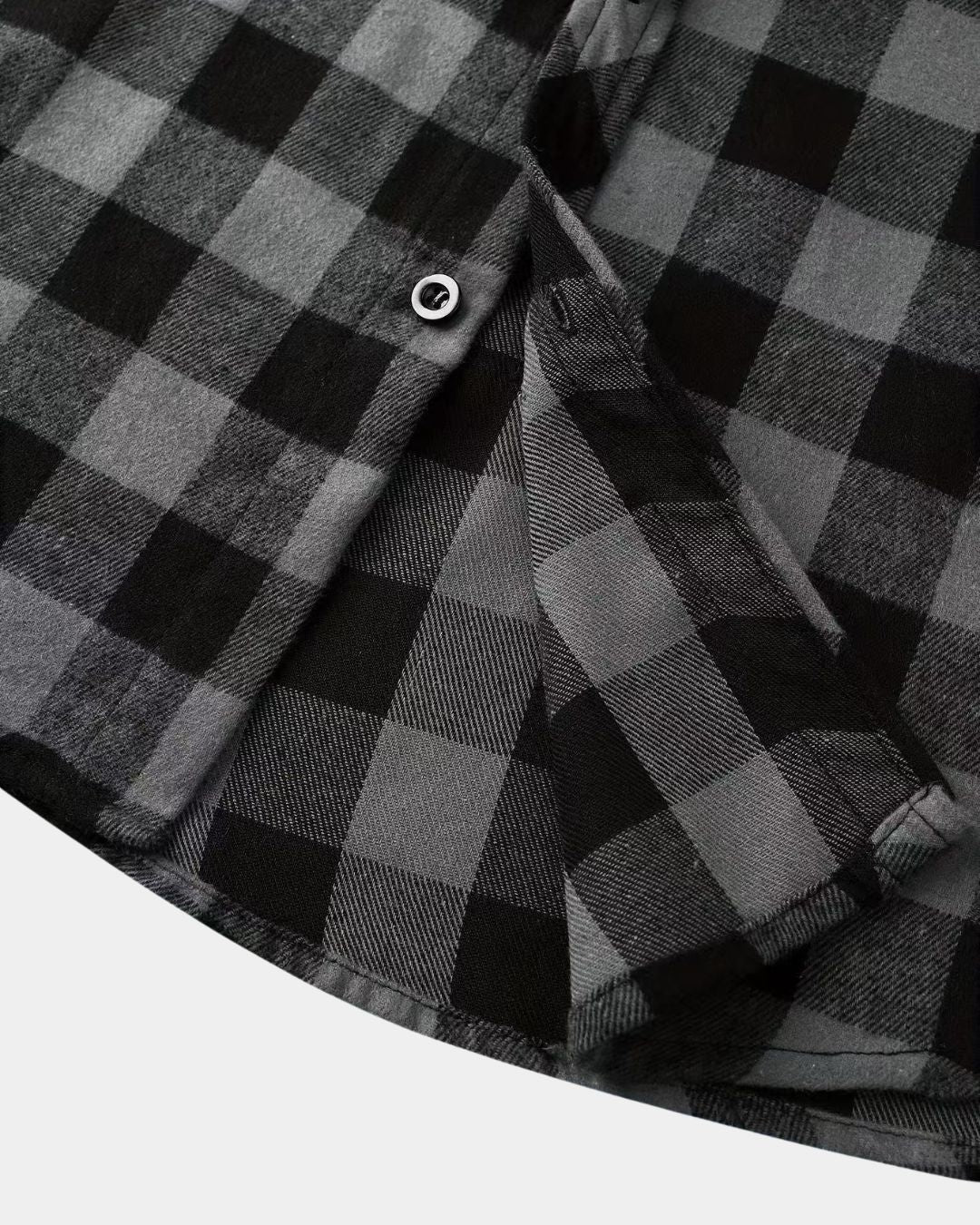 Close-up of a soft, brushed black and grey plaid flannel shirt featuring a button-front design and rugged texture.