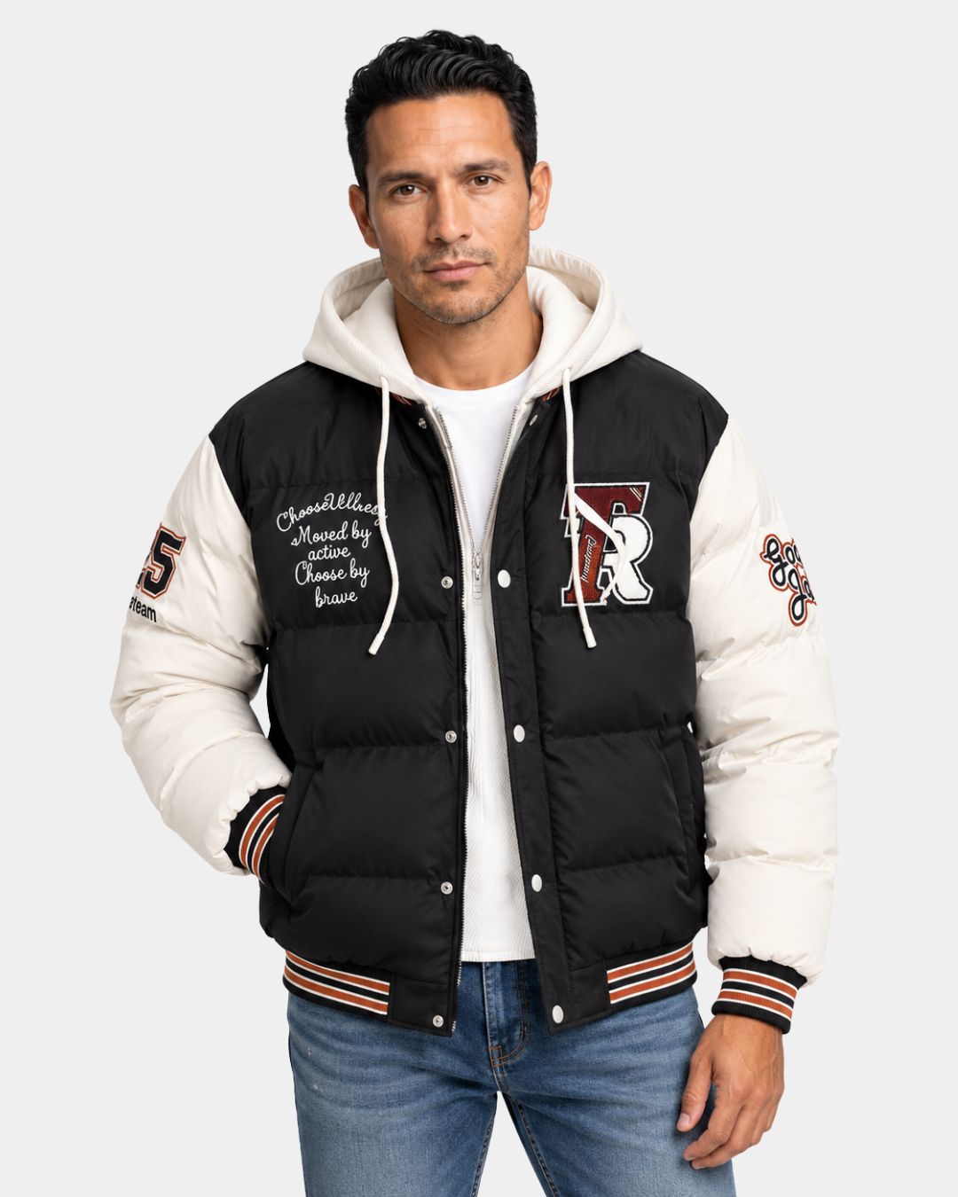 Black and white hooded varsity puffer jacket with embroidered patches, full-zip front, and striped ribbed trim.