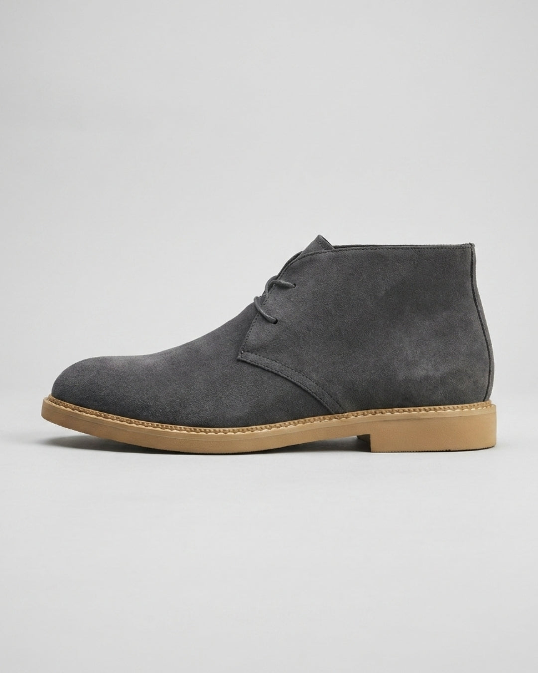 Gray suede men’s chukka boots with a two-eyelet lace-up design, square toe, and a durable tan rubber sole.