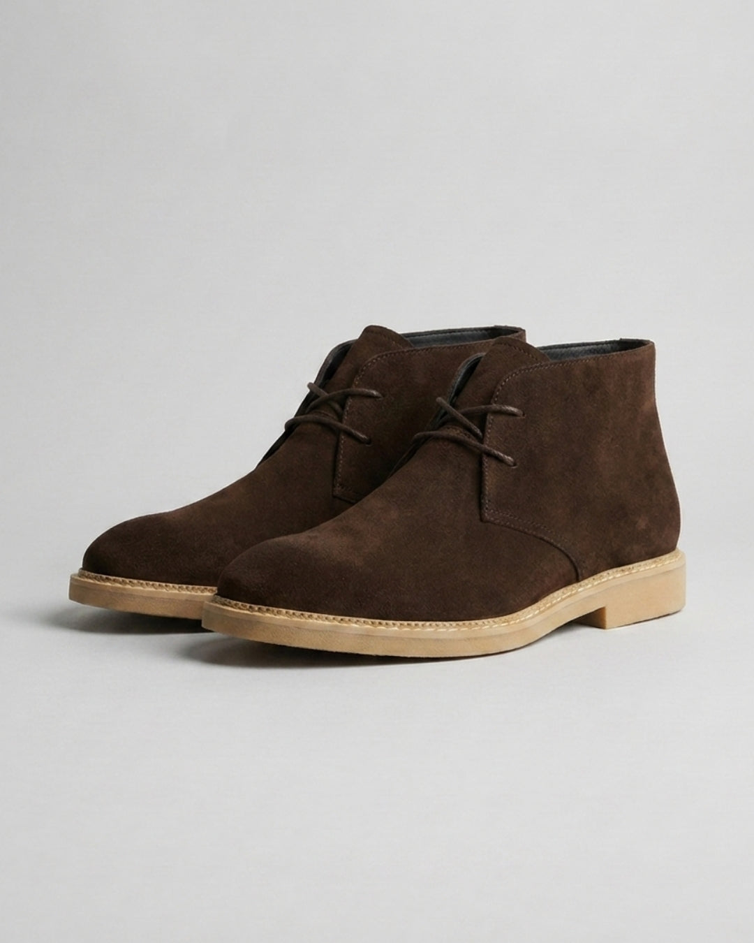 Dark brown suede men's chukka boots with a two-eyelet lace-up design, square toe, and a durable low-profile rubber sole.