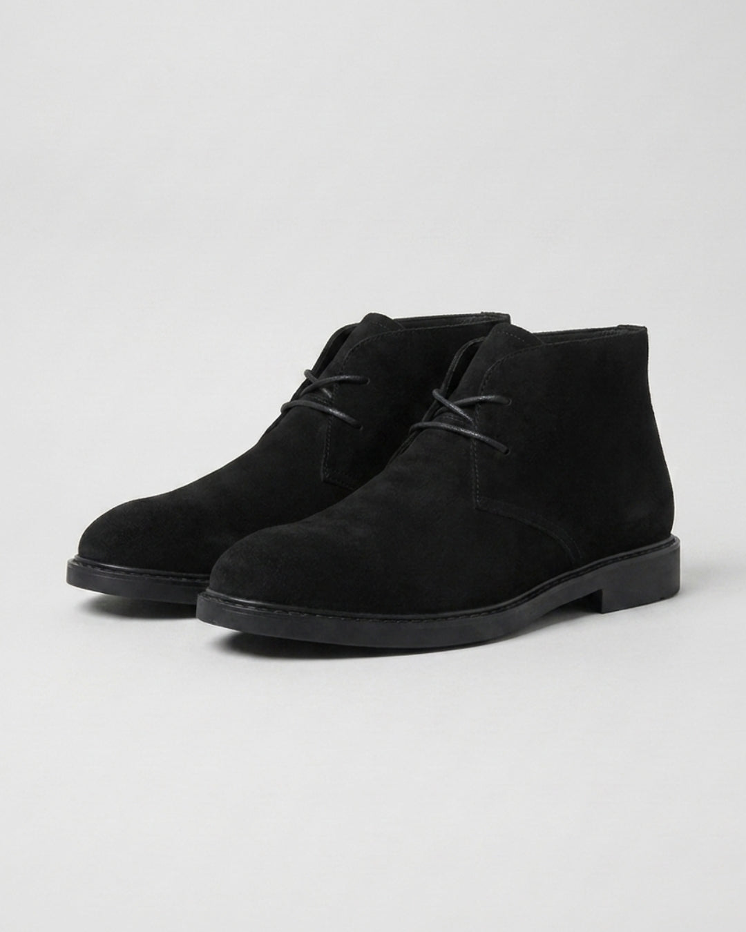 Men’s black suede chukka boots featuring a two-eyelet lace-up design, square toe, and durable low-profile rubber sole.