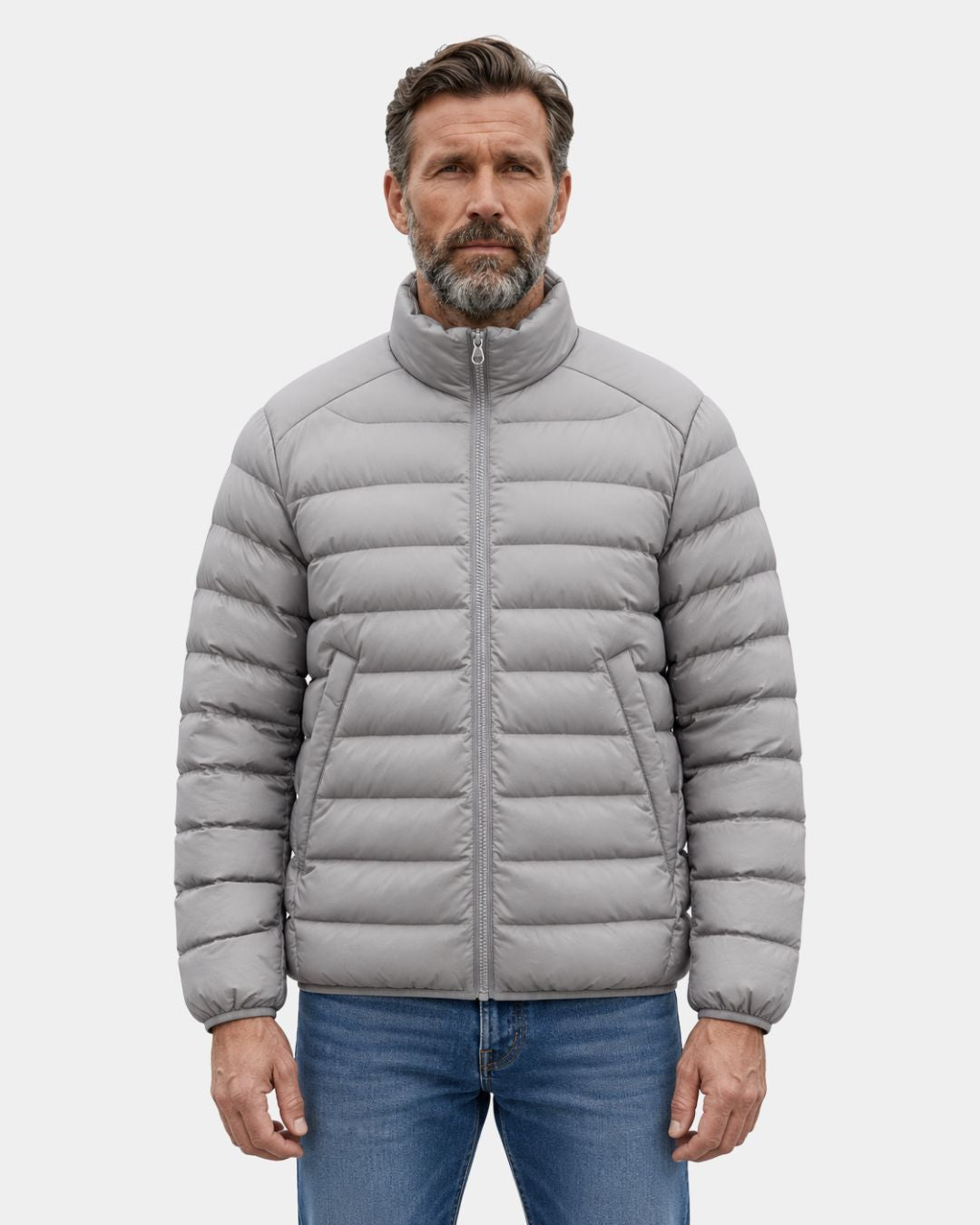 Man wearing a light grey, quilted duck down puffer jacket with a stand collar and full-zip front.