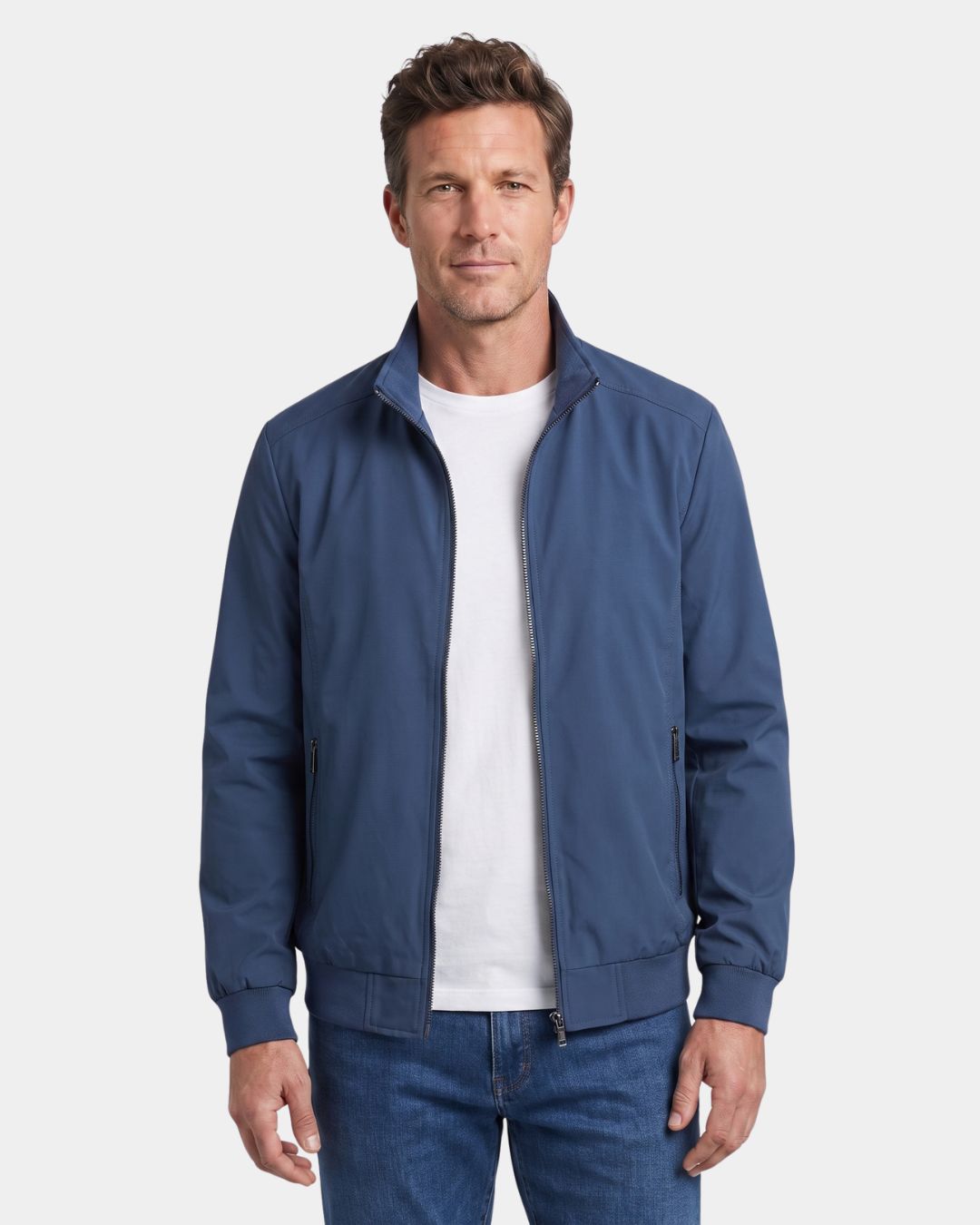 Man wearing a blue lightweight Harrington jacket with a stand collar, zip-front, and ribbed cuffs against a white background.