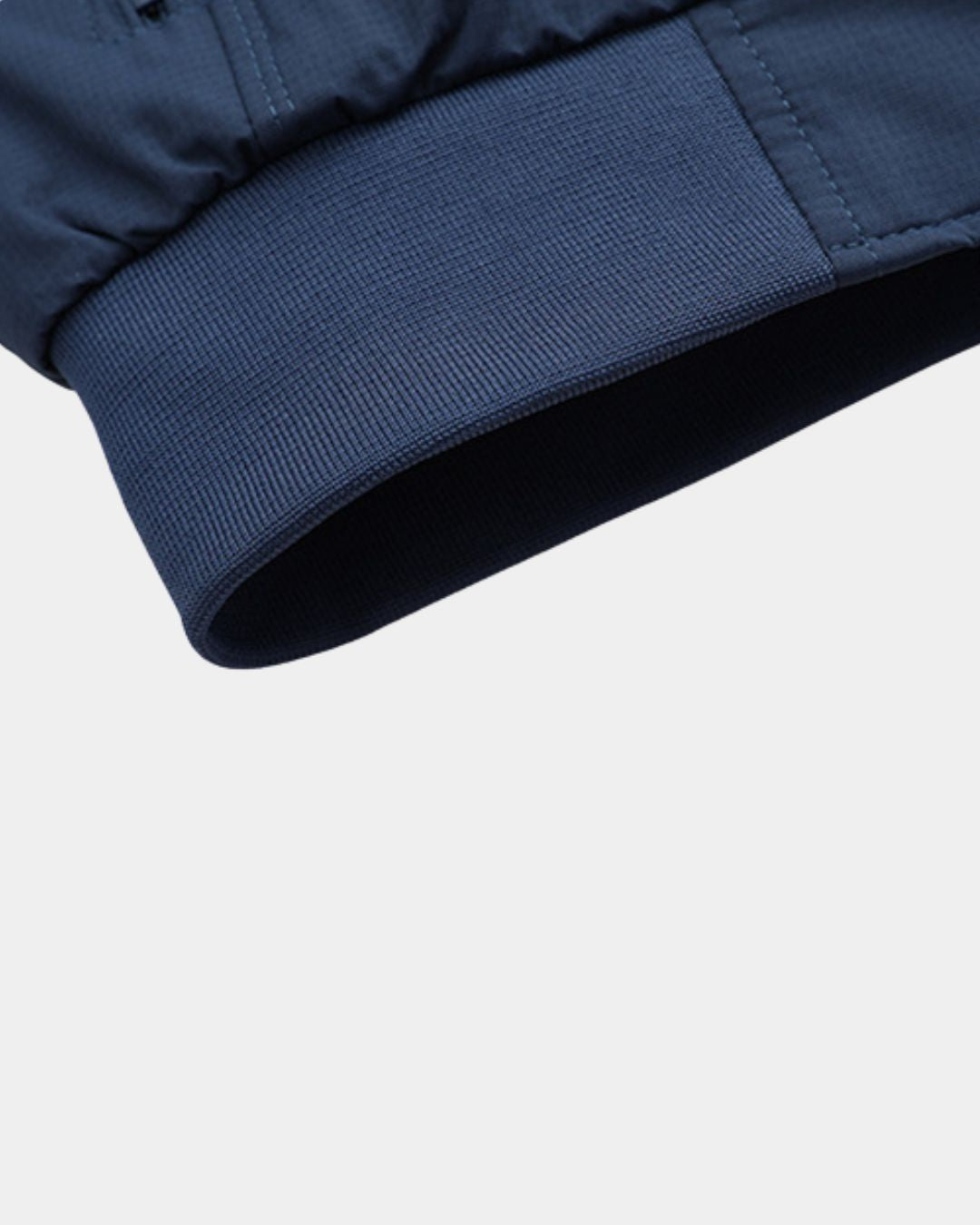 Close-up of a navy blue lightweight Harrington jacket sleeve featuring a ribbed cuff and durable polyester fabric.