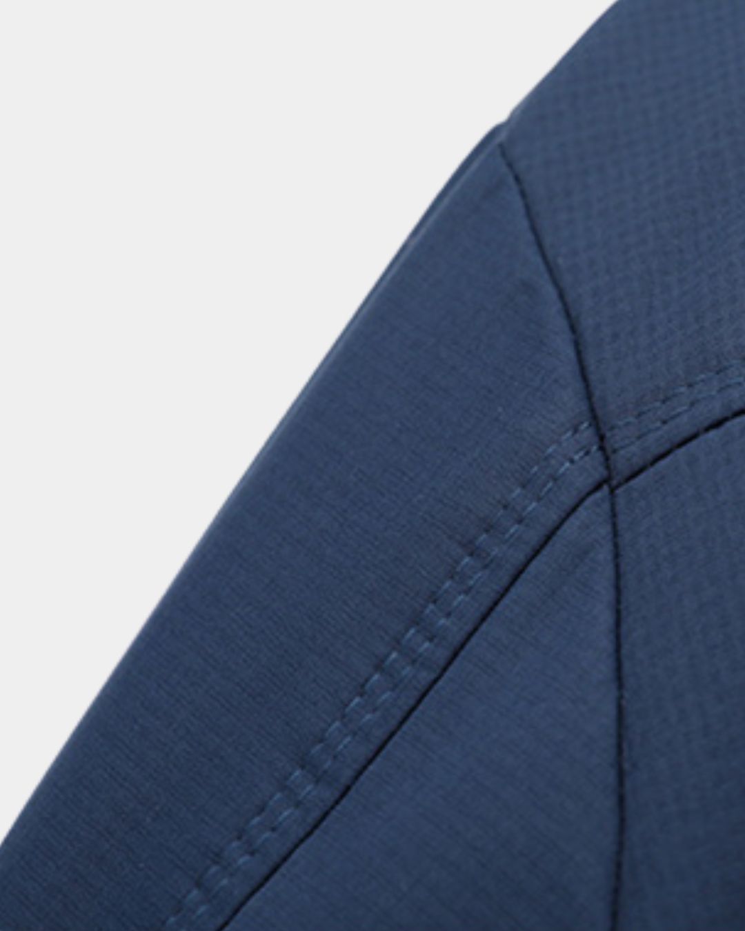 Close-up of a navy blue lightweight polyester Harrington jacket showing detailed stitching and fabric texture.