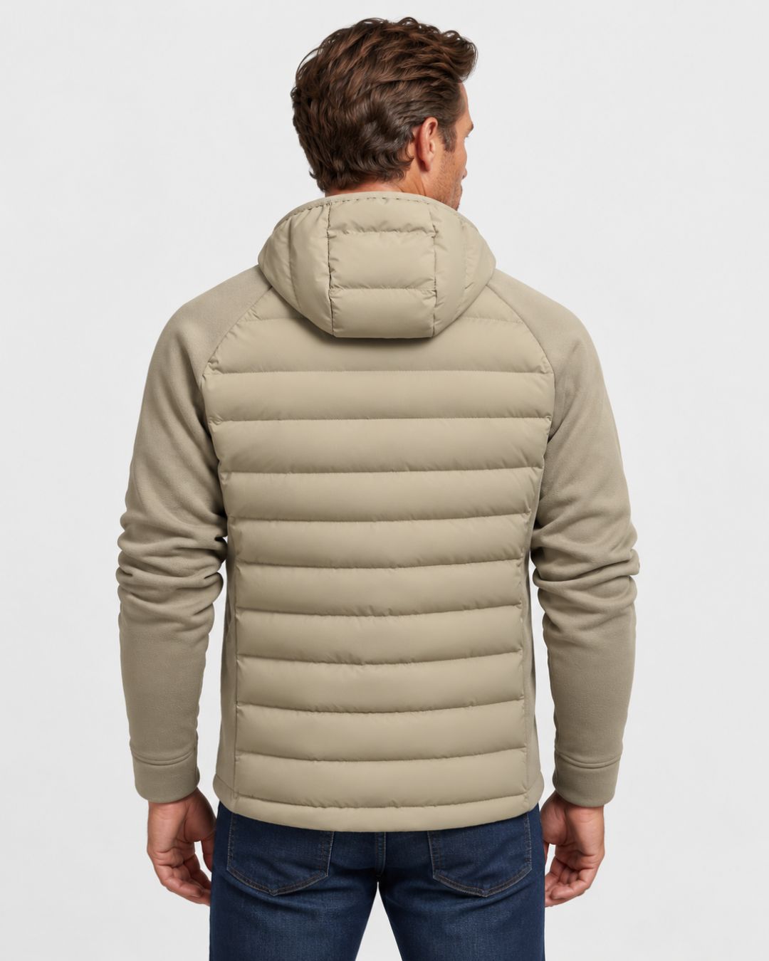Back view of a tan lightweight hybrid puffer jacket with a quilted body, attached hood, and smooth fleece sleeves.