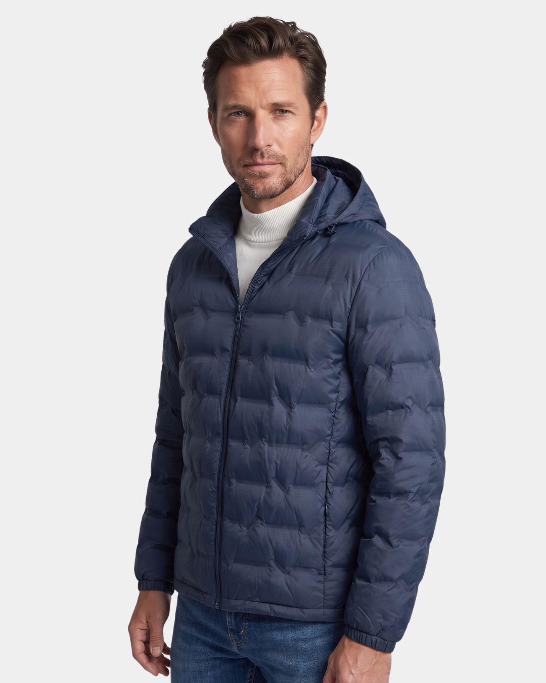 Man wearing a navy blue lightweight quilted down puffer jacket with a detachable hood and full-zip front.