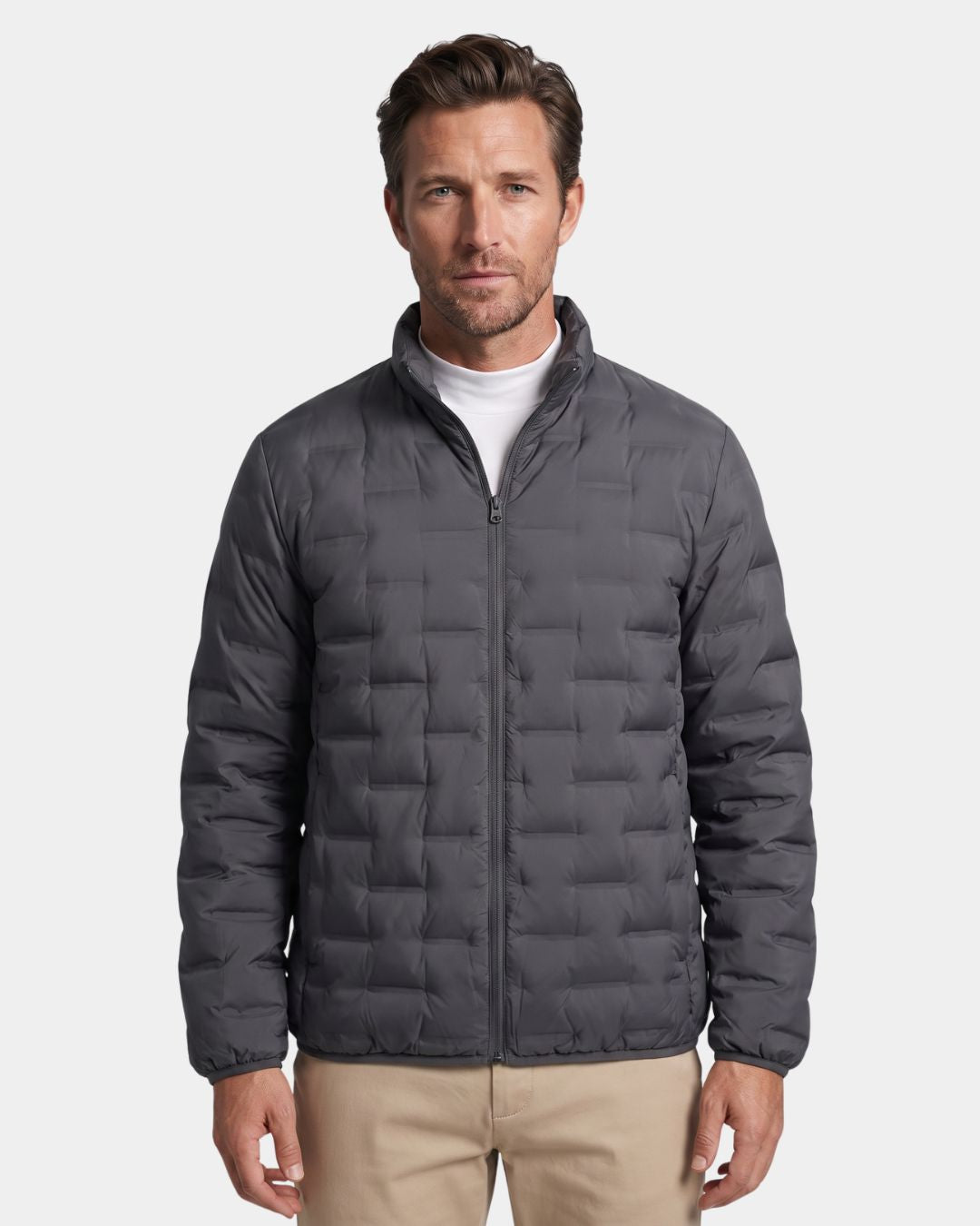 Man wearing a charcoal grey lightweight down puffer jacket with a stand collar and quilted design.