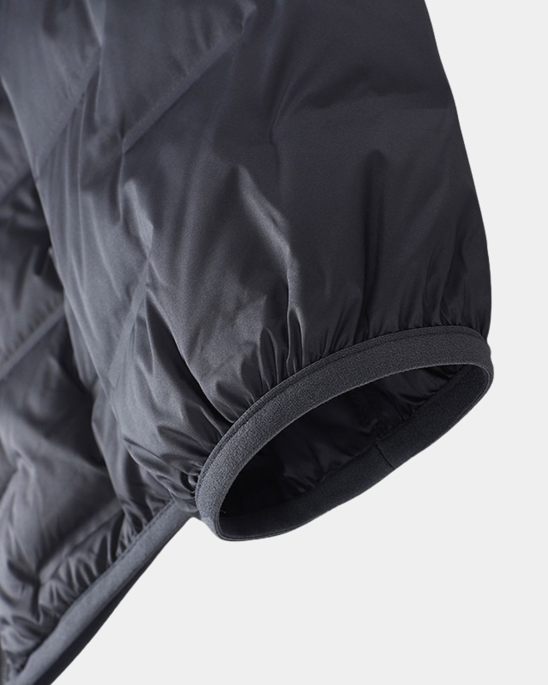 Close-up of a black quilted down puffer jacket sleeve featuring an elasticated cuff with an abrasion-resistant finish.