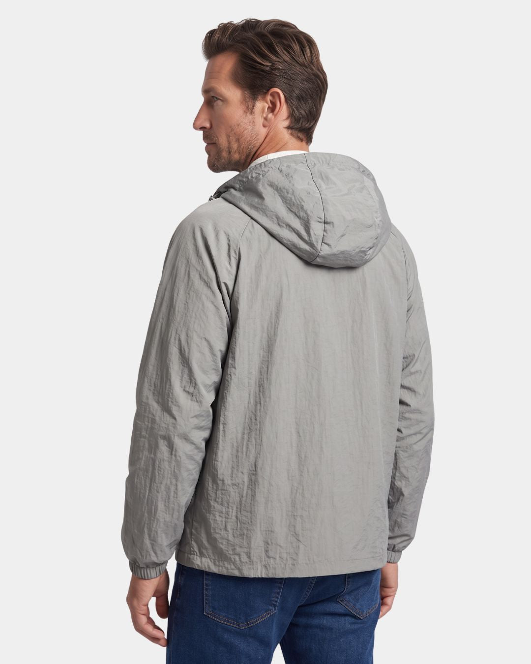 Man wearing a grey, lightweight, hooded waterproof windbreaker jacket with a textured nylon finish.