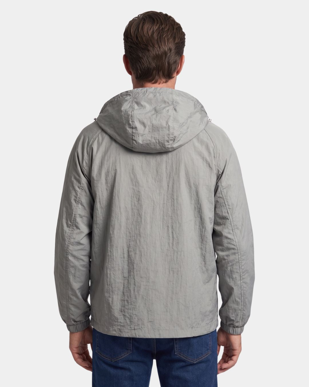 Back view of a man wearing a lightweight, grey hooded waterproof windbreaker jacket with a textured nylon finish.
