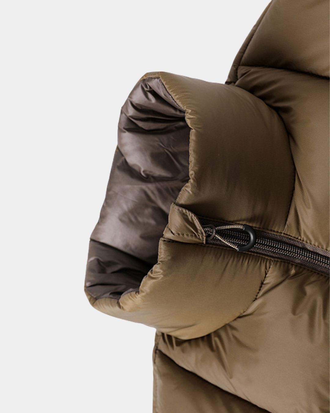Close-up of a brown padded puffer jacket sleeve featuring a durable polyester shell and a secure zippered pocket.