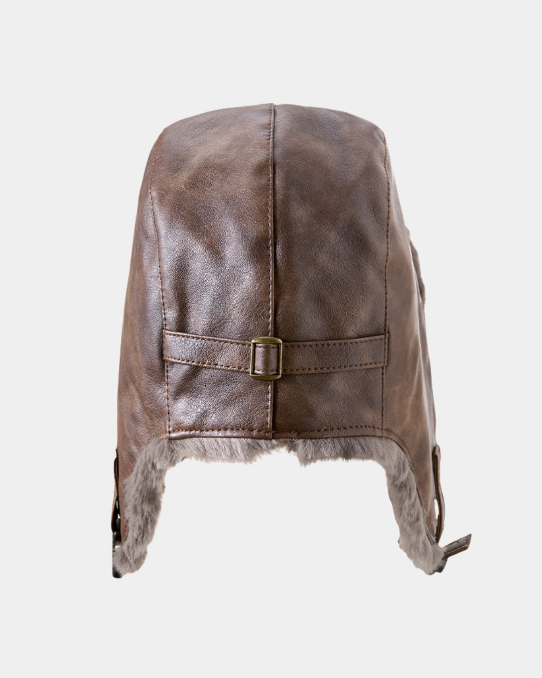 Brown faux leather reversible trapper hat with soft grey fleece lining, ear flaps, and an adjustable brass-tone buckle strap.