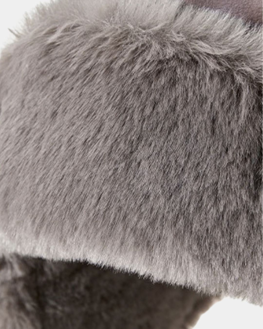 Grey reversible men’s trapper hat featuring plush faux fur lining and ear flaps for winter warmth.
