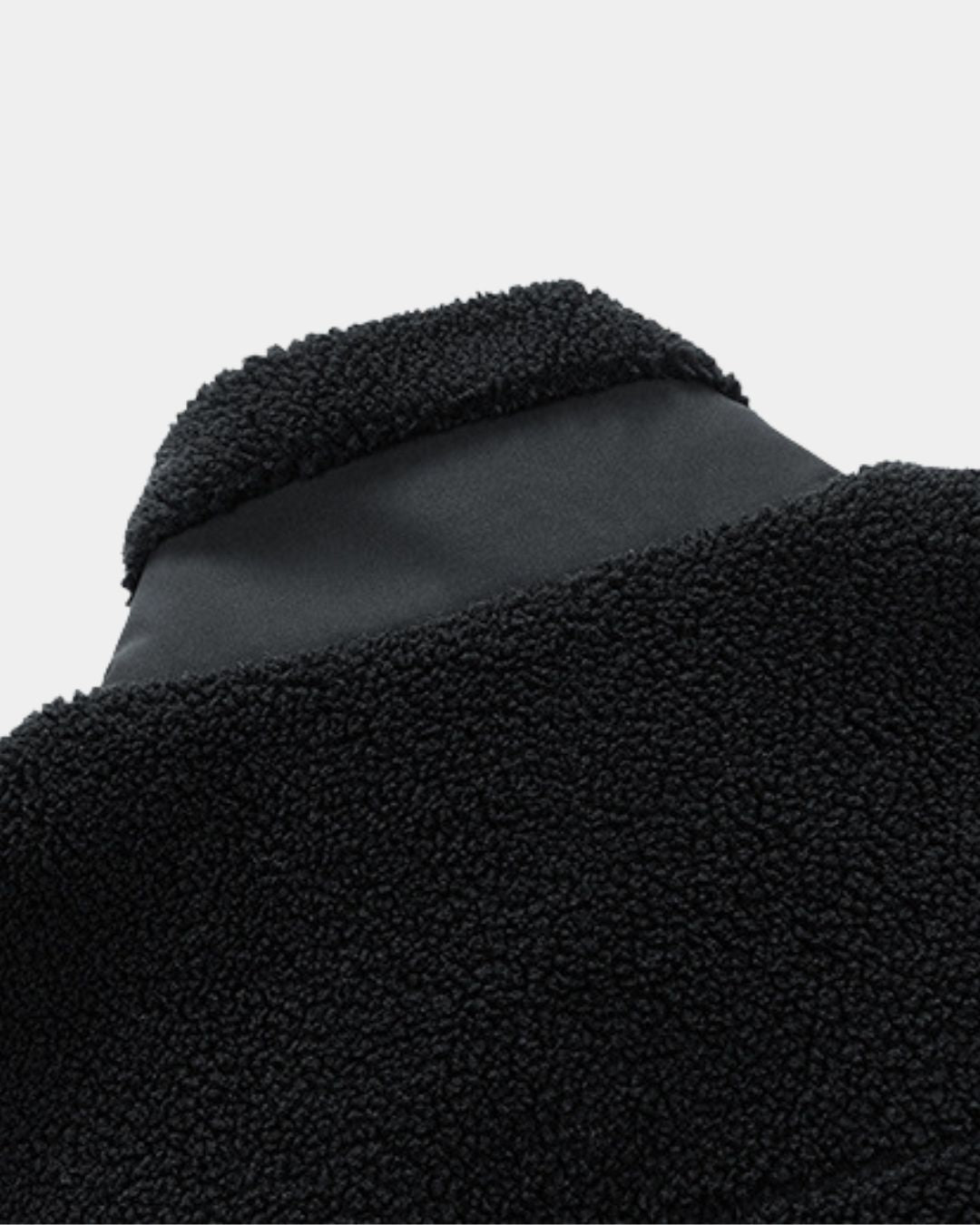 Black men’s sherpa fleece utility jacket with a stand collar and smooth contrast panel detail.