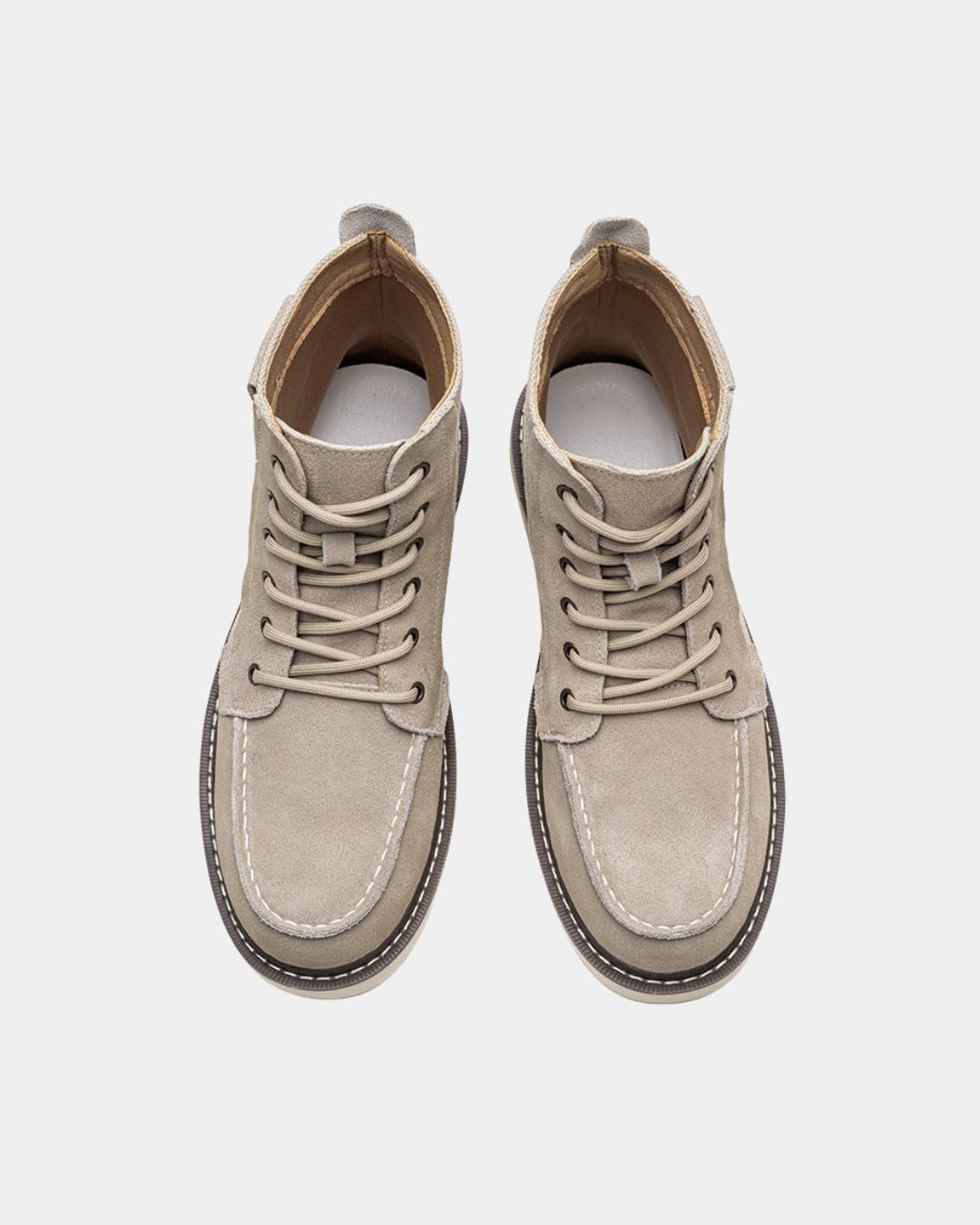 Beige suede men's moc toe ankle boots with lace-up closure, canvas panels, and a chunky rubber outsole.