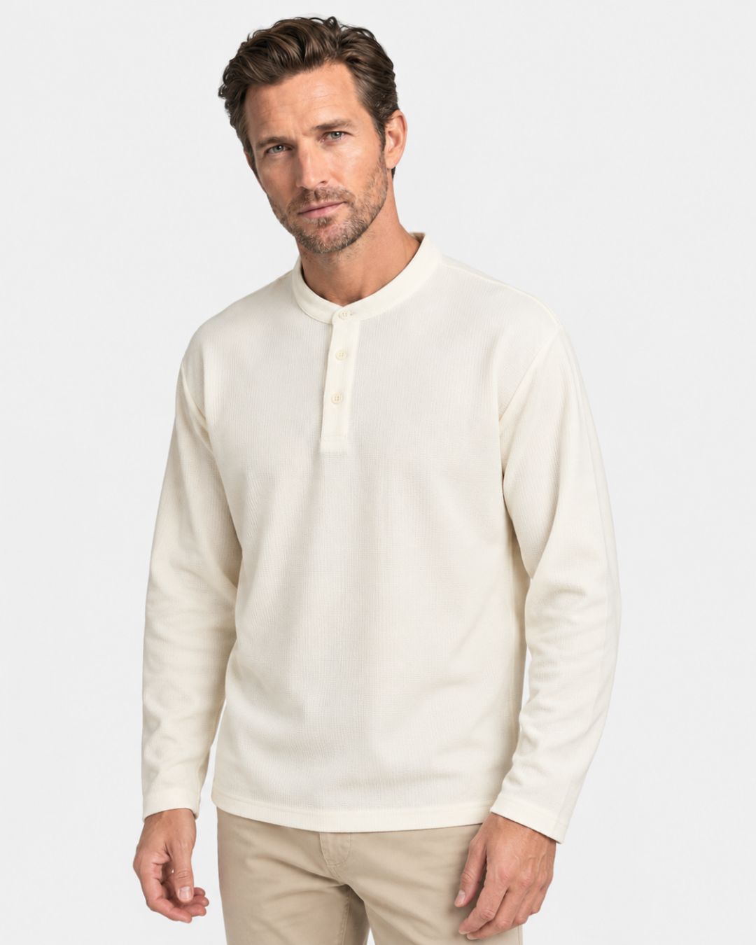 Men’s cream long sleeve henley shirt in a textured waffle knit with a three-button band collar and dropped shoulders.