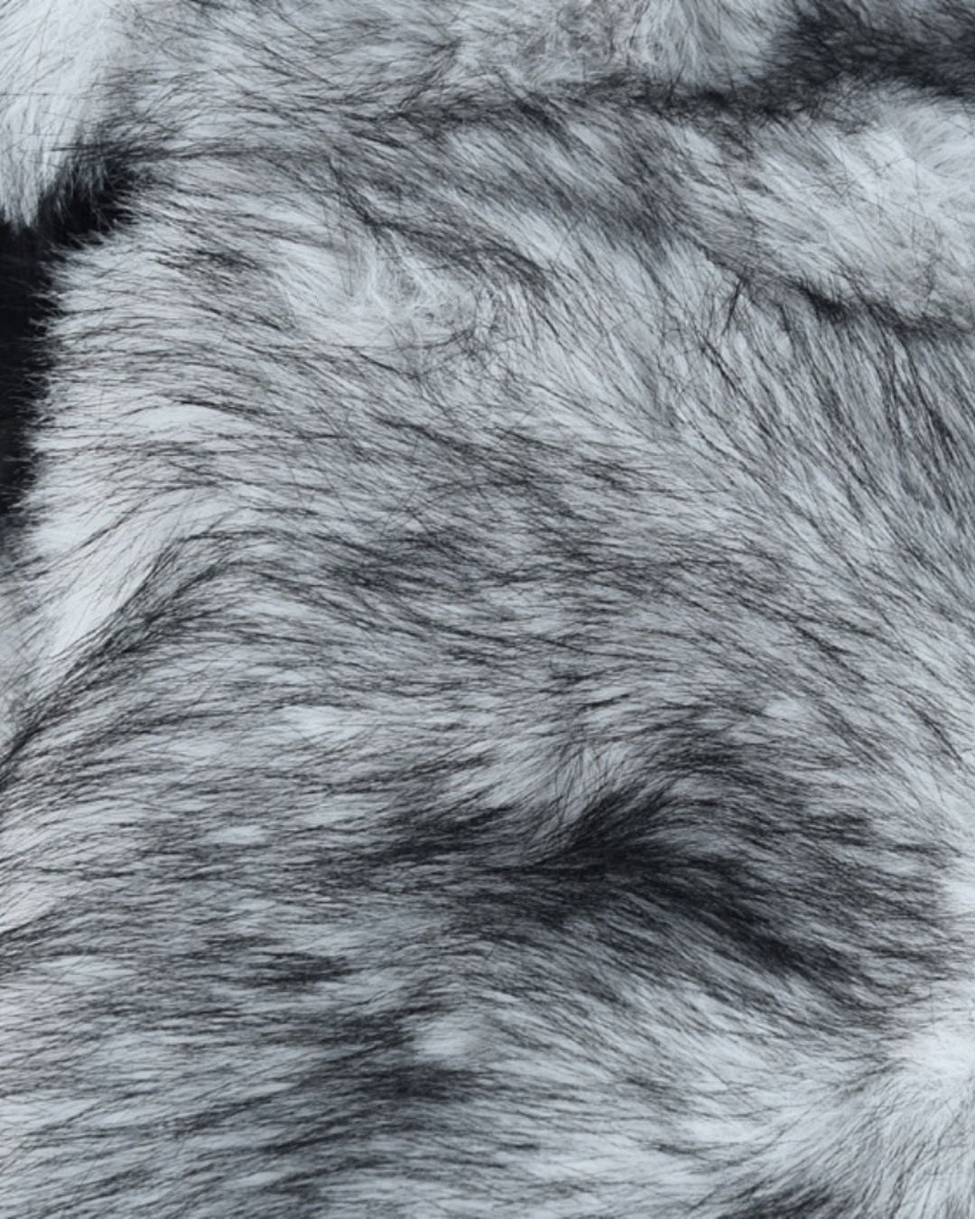 Close-up texture of a soft, grey and black faux fur ushanka trapper hat for winter warmth.
