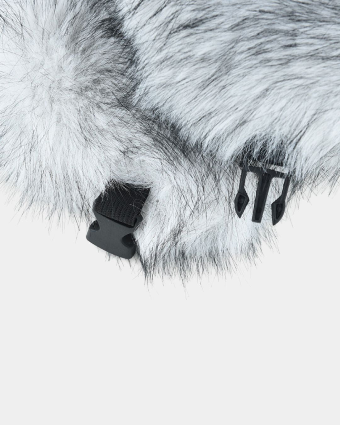 Close-up of a grey and white plush ushanka trapper hat featuring a black plastic buckle strap for a secure fit.