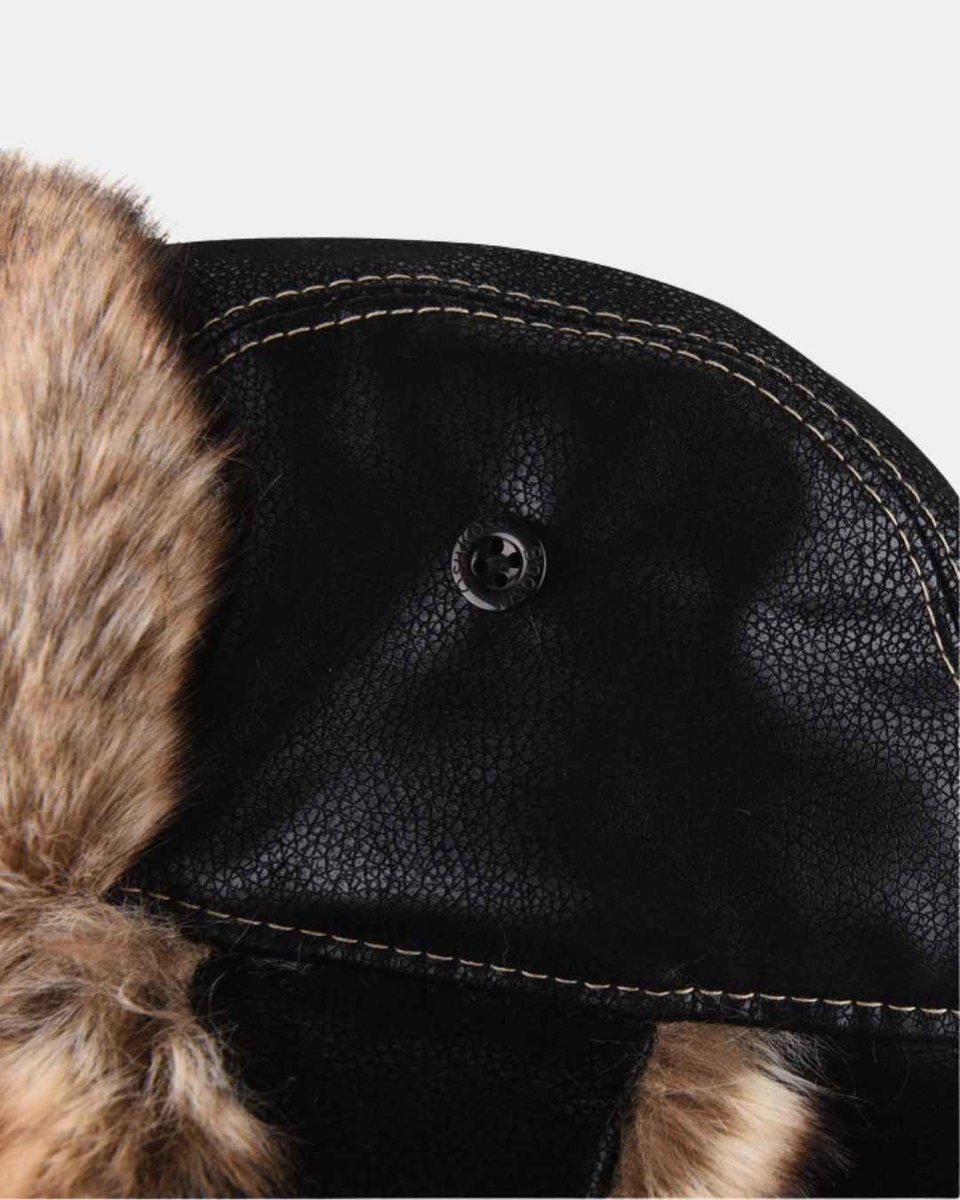 Black faux leather aviator trapper hat with tan plush faux fur trim and a button detail on the side ear flap.