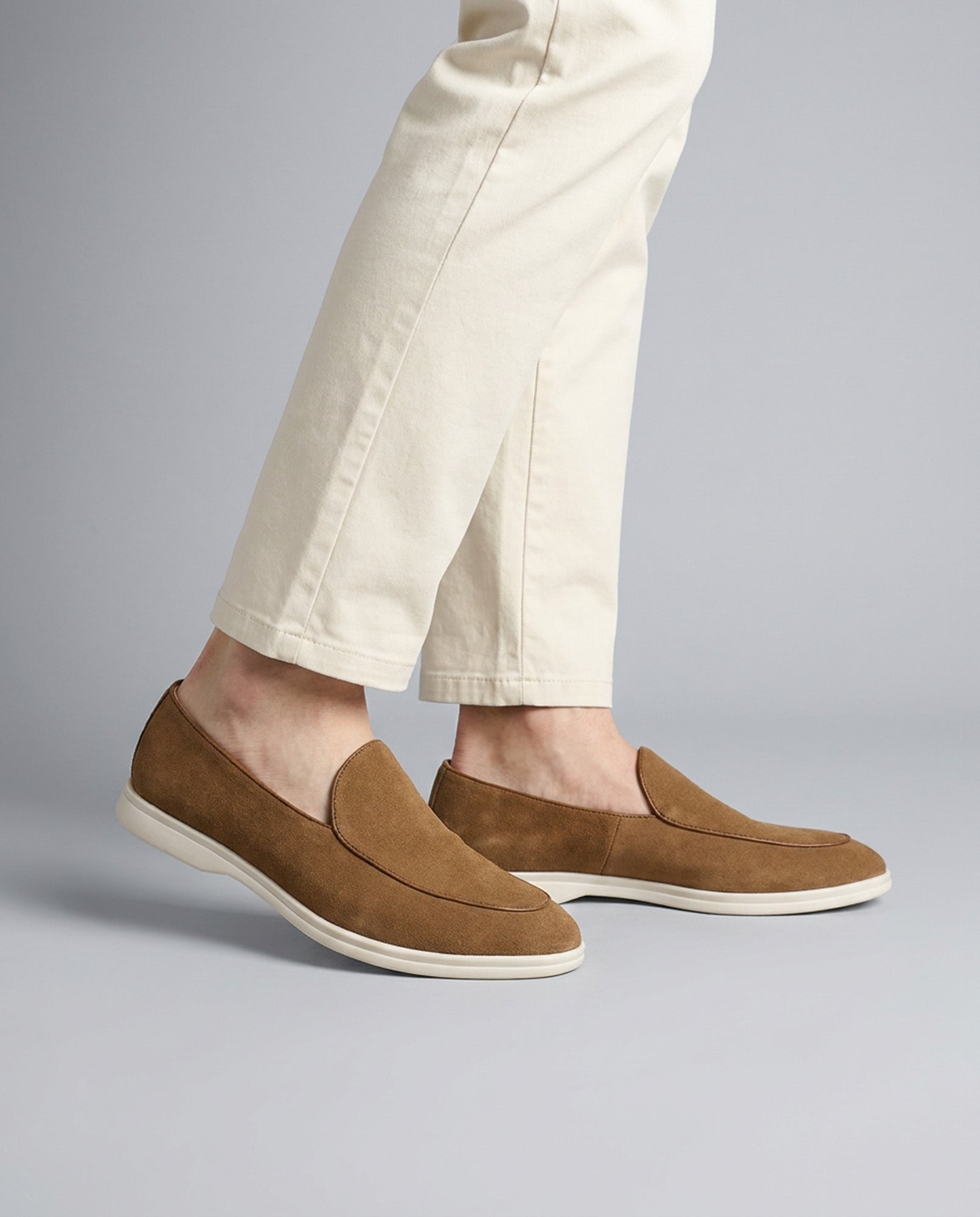 Milan men's tan suede slip-on loafers worn with cream trousers