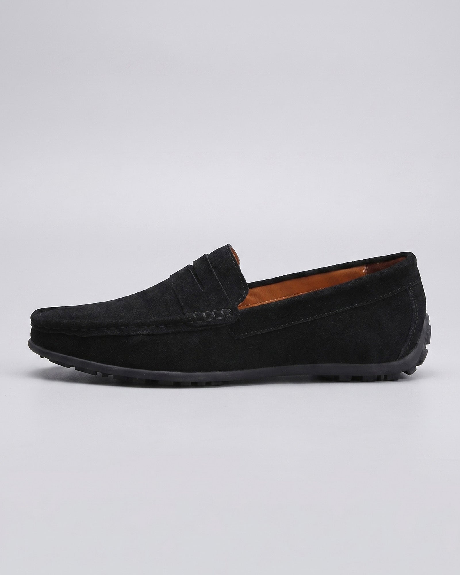 Side view of Nigel men's black suede driving loafer with tonal penny strap and moccasin toe