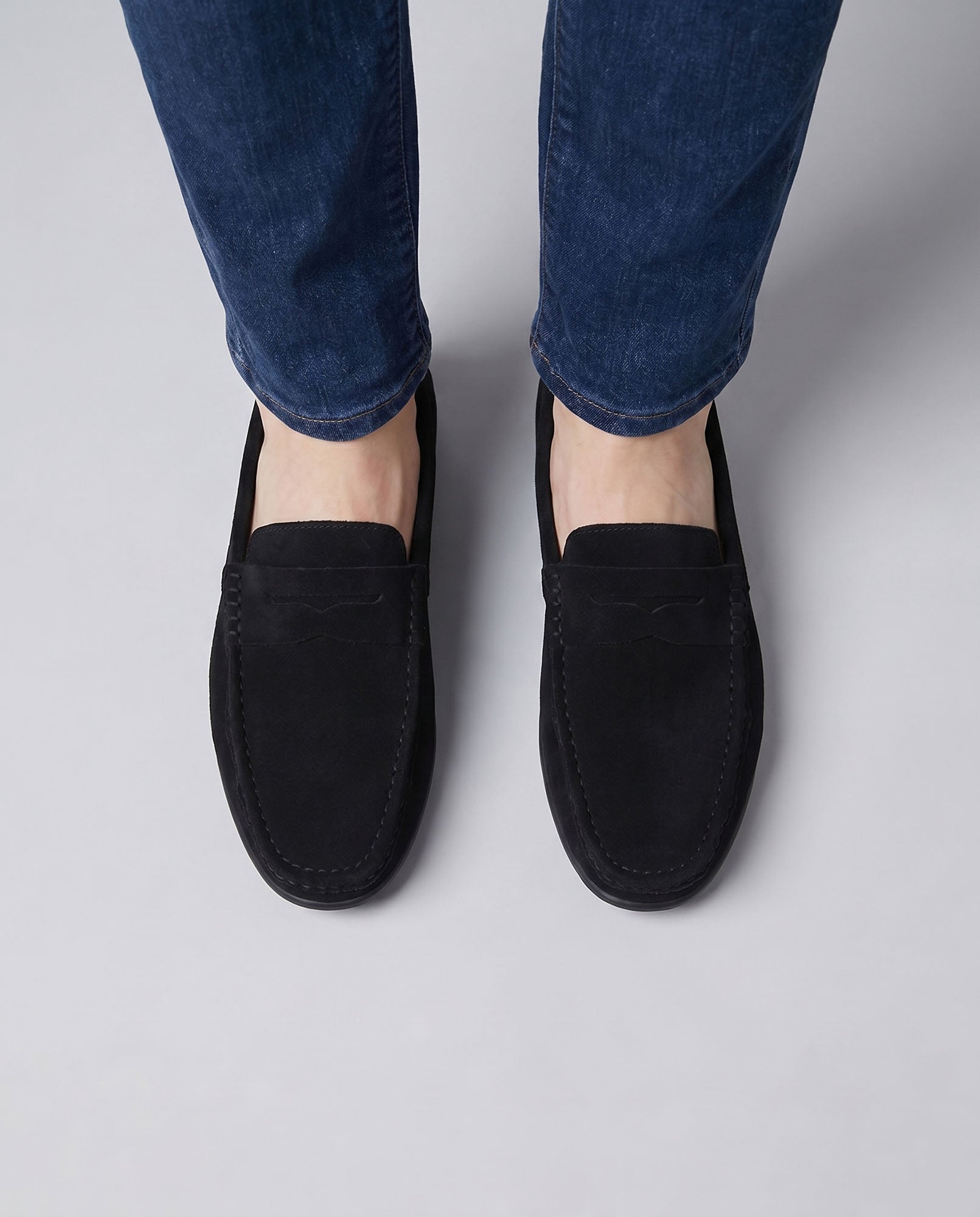 Overhead front view of Nigel men's black suede driving loafers worn with blue denim jeans