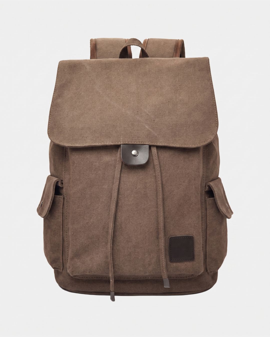 A brown canvas backpack with a large front flap, drawstring closure, side pockets, and a small dark brown brand patch on the lower right front, by Hudson & Tate.