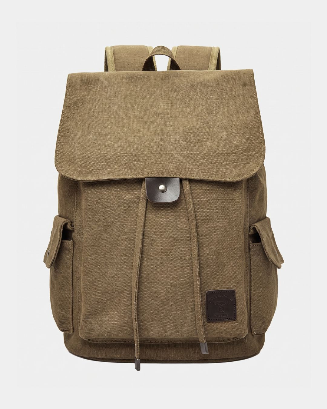 A khaki canvas backpack with a large front flap, drawstring closure, side pockets, and a small dark brown leather patch on the lower right front, by Hudson & Tate.
