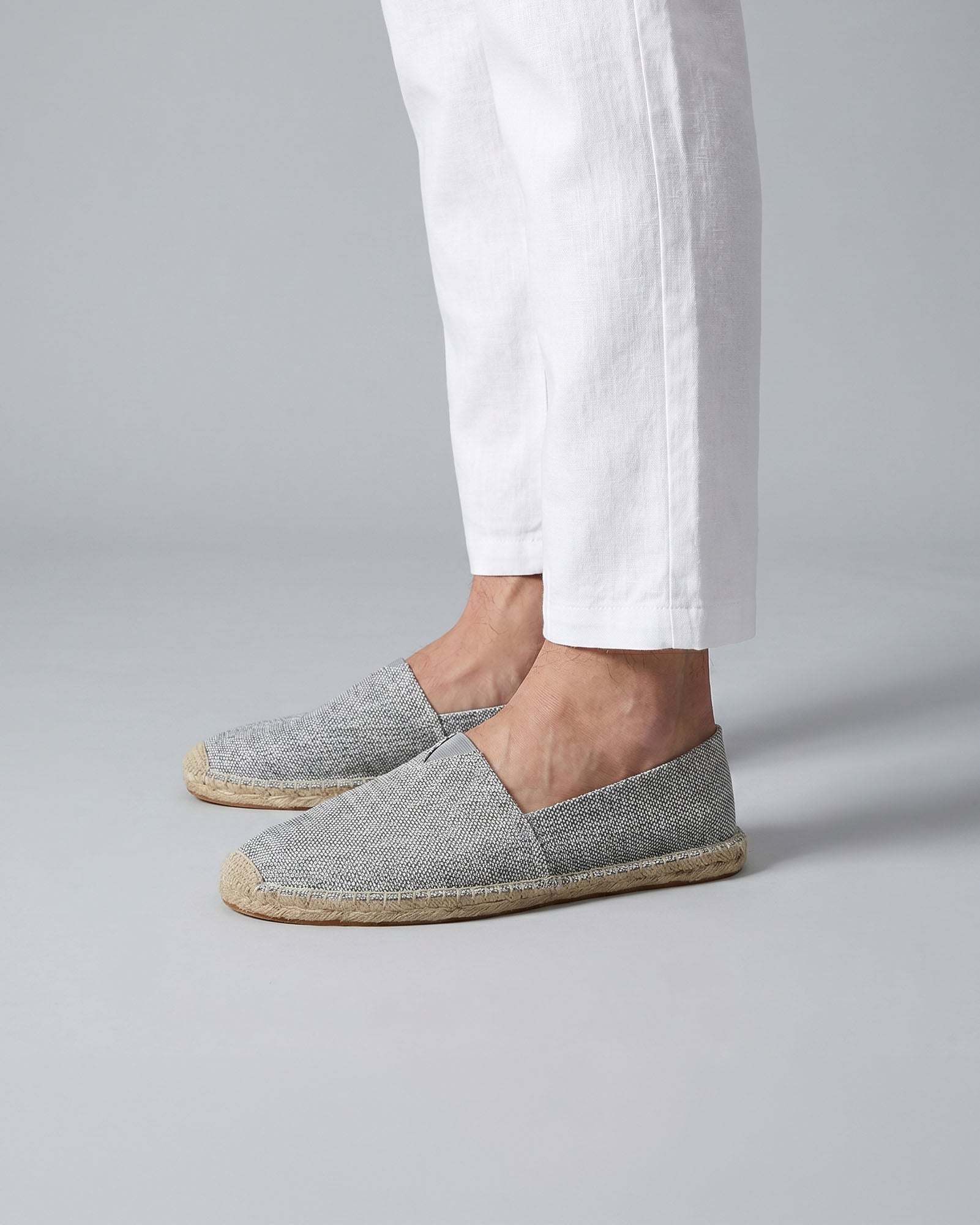 Tulum men's gray canvas espadrille loafers worn with white trousers